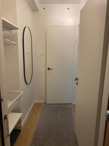 a hallway with a white door and a mirror at Modern apartment with parking in Helsinki