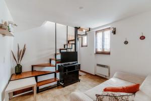 a living room with a staircase and a couch at La Casetta di Riva - Cozy home in lakeside village in Riva San Vitale