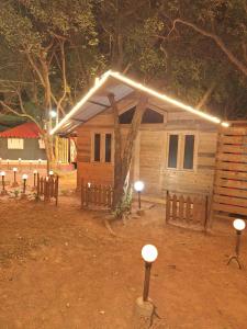 a wooden cabin with lights on top of it at Nature Glamping in Matheran