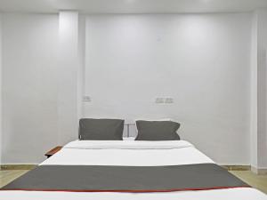 a white bed with two pillows in a room at Collection O The Pinaki Residency Near Dlf Avenue Saket in New Delhi