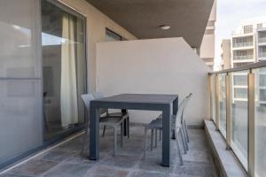 a blue table and chairs on a balcony at Seabreeze Luxury Apartment in St Paul's Bay