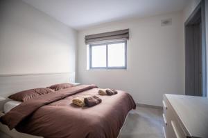 1 dormitorio con 1 cama con 2 toallas en Seabreeze Luxury Apartment en St Paul's Bay