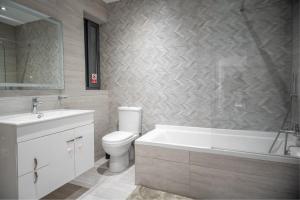 een badkamer met een bad, een toilet en een wastafel bij Seabreeze Luxury Apartment in St Paul's Bay