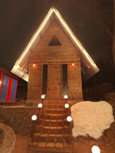 a small house with lights on the stairs at night at Nature Glamping in Matheran