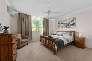 - une chambre avec un lit, une chaise et une fenêtre dans l'établissement Terrific & Tranquil! 1Bed/1Bath/Balcony~ Clayfield, à Brisbane