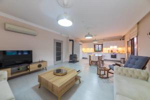 ein Wohnzimmer mit einem Sofa und einem Tisch in der Unterkunft Denis Villa in Muğla