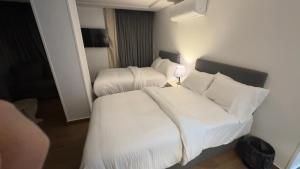 um quarto de hotel com duas camas e um sofá em لوكاندة الحصري أكتوبر motel elhosary em Cidade 6 de Outubro
