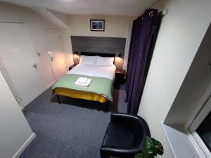 una pequeña habitación con una cama y una silla en Osney Hazel Studio - Self Contained Studio Flat, en Oxford 12 fotos más