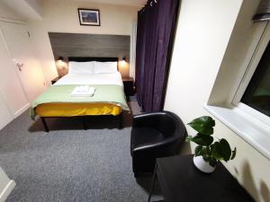 une chambre d'hôtel avec un lit et une chaise dans l'établissement Osney Hazel Studio - Self Contained Studio Flat, à Oxford