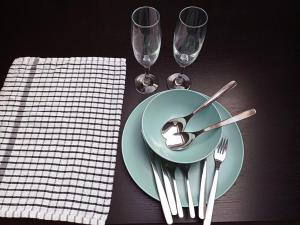 uma mesa com um prato com uma colher e dois copos de vinho em Osney Hazel Studio - Self Contained Studio Flat em Oxford