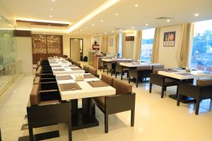 een eetkamer met tafels en stoelen in een restaurant bij RAS Hotels in Kumbakonam