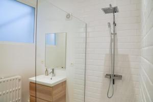 迪南的住宿－Appartement tout confort au centre ville de DINANT，白色的浴室设有水槽和淋浴。