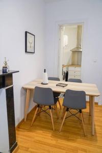 a wooden table with four chairs in a room at Appartement tout confort au centre ville de DINANT in Dinant