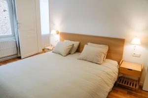 a bedroom with a large white bed with two pillows at Appartement tout confort au centre ville de DINANT in Dinant
