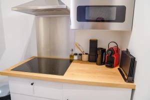 a kitchen with a counter top with a microwave at Appartement tout confort au centre ville de DINANT in Dinant +2 photos