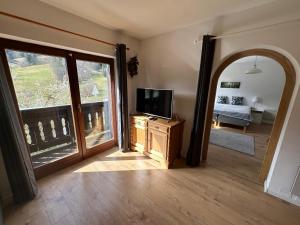 a living room with a tv and a mirror at Piano Annaberg Apartments in Annaberg