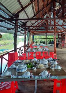 einen Tisch mit Schalen und Teller mit Lebensmitteln darauf in der Unterkunft Homestay Nguyễn Hùng in Rạch Tàu