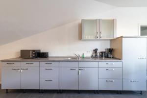 a kitchen with white cabinets and a sink at 105qm Wohnung für max. 7 Personen in Königstein im Taunus +9 photos