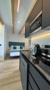 Zimmer mit einer Küche und einem Bett im Hintergrund in der Unterkunft Apart-hotel Happy Life in Alicante