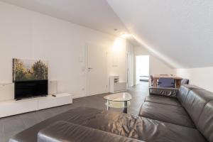 a living room with a couch and a tv at 105qm Wohnung für max. 7 Personen in Königstein im Taunus