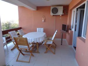 een eetkamer met een tafel en stoelen op een balkon bij Apartment Golf in Star Dojran