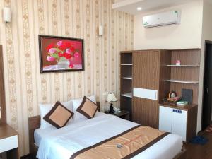 a bedroom with a bed and a picture on the wall at Tiến Lộc Plaza Hotel in Hà Nam