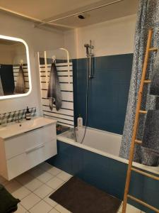 Un baño con bañera, lavabo y ducha. en La Cabane du Roc, en Granville