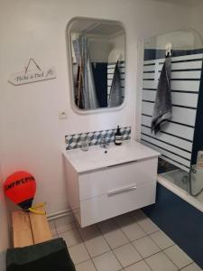 un baño con lavabo y espejo en La Cabane du Roc, en Granville 23 fotos más