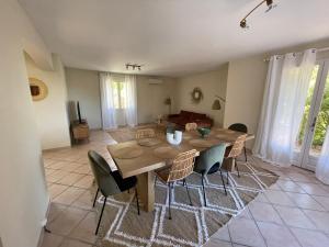 Belle villa provençale avec piscine privée في كاركيران: غرفة طعام مع طاولة وكراسي خشبية