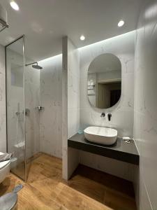 bagno con lavandino e specchio di Paradise Lost Hotel-Apartments a Tolo