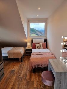 a bedroom with two beds and a window at Deluxe Ferienwohnung Schwarzwald, 8 Personen, 140 qm, Haus Sonnenschein in Todtnau