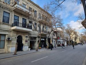 um prédio numa rua com pessoas andando pela rua em Malakan apartment em Baku