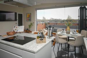 a kitchen and living room with a table and chairs at Stunning Luxury 3 Bed Penthouse Sleeps 2 to 6 in Hythe