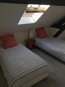 two beds in a attic room with a skylight at Le Sémaphore in Fécamp