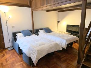 2 Betten in einem Zimmer mit einem TV in der Unterkunft GuestHost trilo x5 - 7 stops from Duomo in Mailand + 15 Fotos