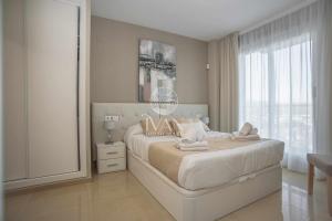 Un dormitorio blanco con una cama grande y una ventana. en Casa Bibi Ivan Luxury Homes 4ªPlta Sur 1ªLinea, en Oropesa del Mar