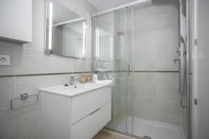 Un baño blanco con lavabo y ducha. en Casa Bibi Ivan Luxury Homes 4ªPlta Sur 1ªLinea, en Oropesa del Mar 16 fotos más