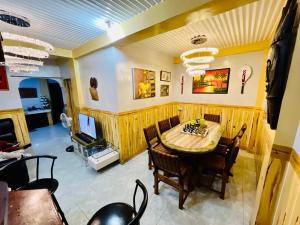 una sala da pranzo con tavolo, sedie e TV di Baguio Cozy Home a Baguio