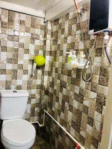 La salle de bains est pourvue d'une douche et de toilettes. dans l'établissement Baguio Cozy Home, à Baguio