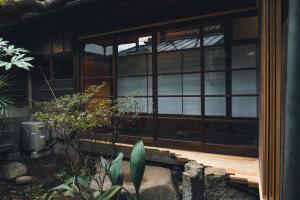 une maison avec une terrasse couverte en bois et une fenêtre dans l'établissement Johns House じょんのやど, à Himeji