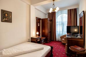 ピテシュティにあるHotel Victoriaのベッドとテレビが備わるホテルルームです。