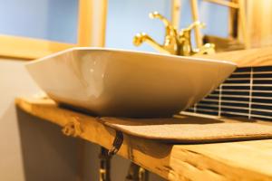 a white sink sitting on top of a wooden counter at Johns House じょんのやど in Himeji