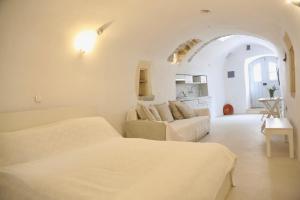 a white room with two beds and a couch at Axion Studios in Aroniadika