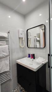 a bathroom with a sink and a mirror at HOTEL PARIS PANAM-PERE LACHAISE-PLACE GAMBETTA-HOPITAL TENON-REPUBLIQUe in Paris +149 photos