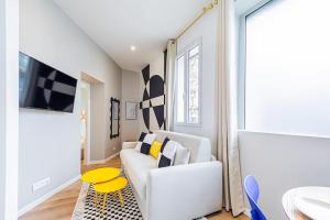 un soggiorno con divano bianco e tavolo giallo di Appartement cosy proche de la capitale a Bagnolet