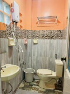 a bathroom with a toilet and a sink at Cozy 1BR Unit with Full Bathroom,Kitchen, Wifi at Sonia's Island Stay in Virac