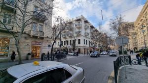 a white car parked on the side of a city street at Central Park apartment in Baku