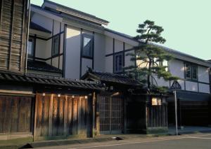 金沢市にあるカメリアイン雪椿の木の扉と木の前の建物