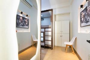 a room with two white chairs and a hallway at Dorms Bui Vien - Walking street in Ho Chi Minh City