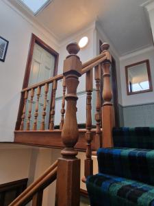 a wooden spiral staircase in a house with a window at Carradale Guest House in Lerwick